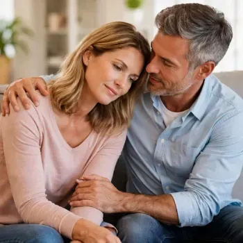 Een vrouw leunt tegen haar partner aan op de bank als teken van emotionele steun bij chronische ziekte